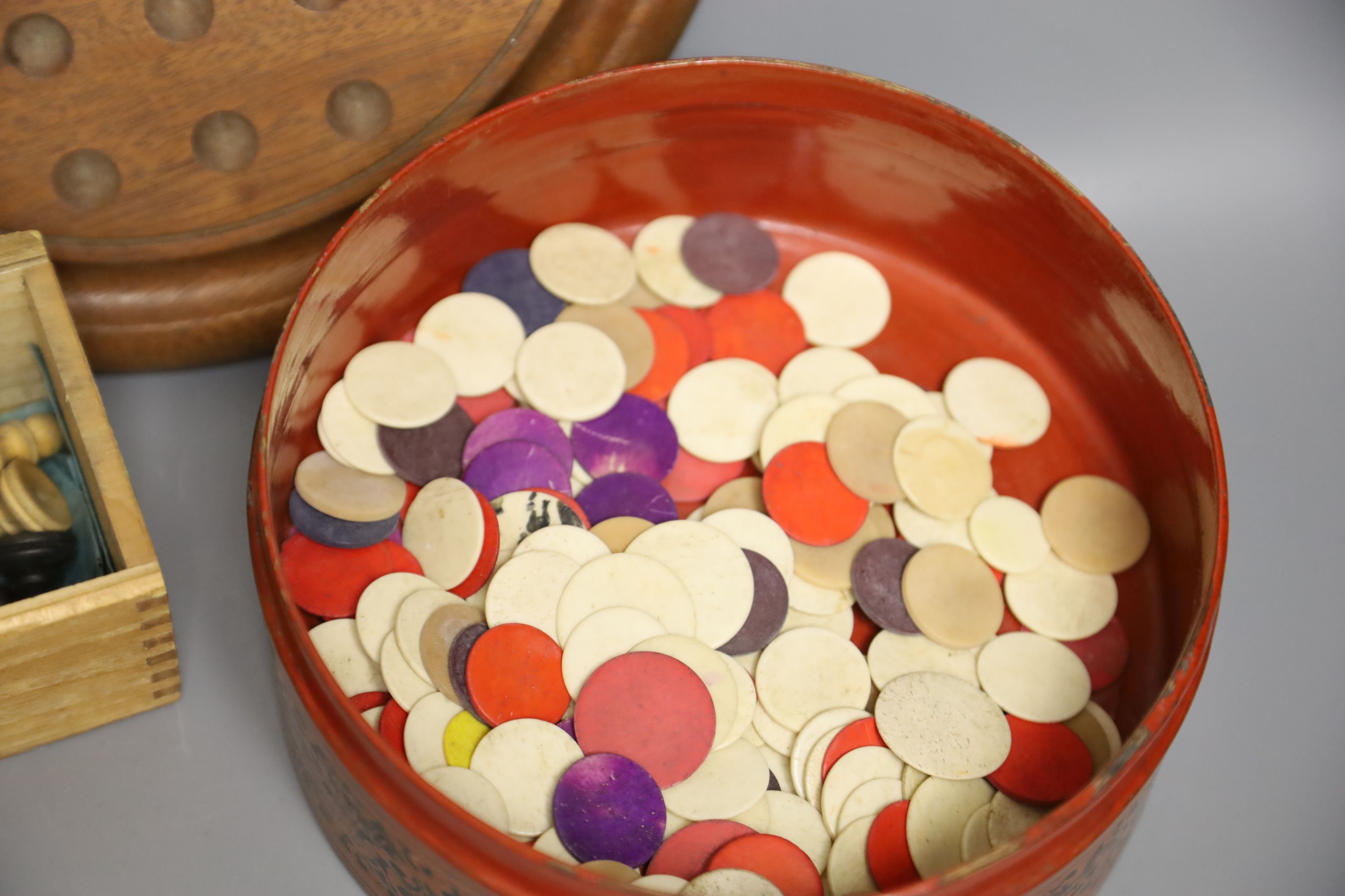 A quantity of marbles, boxwood chess pieces, a solitaire board and bone scrabble pieces and counters